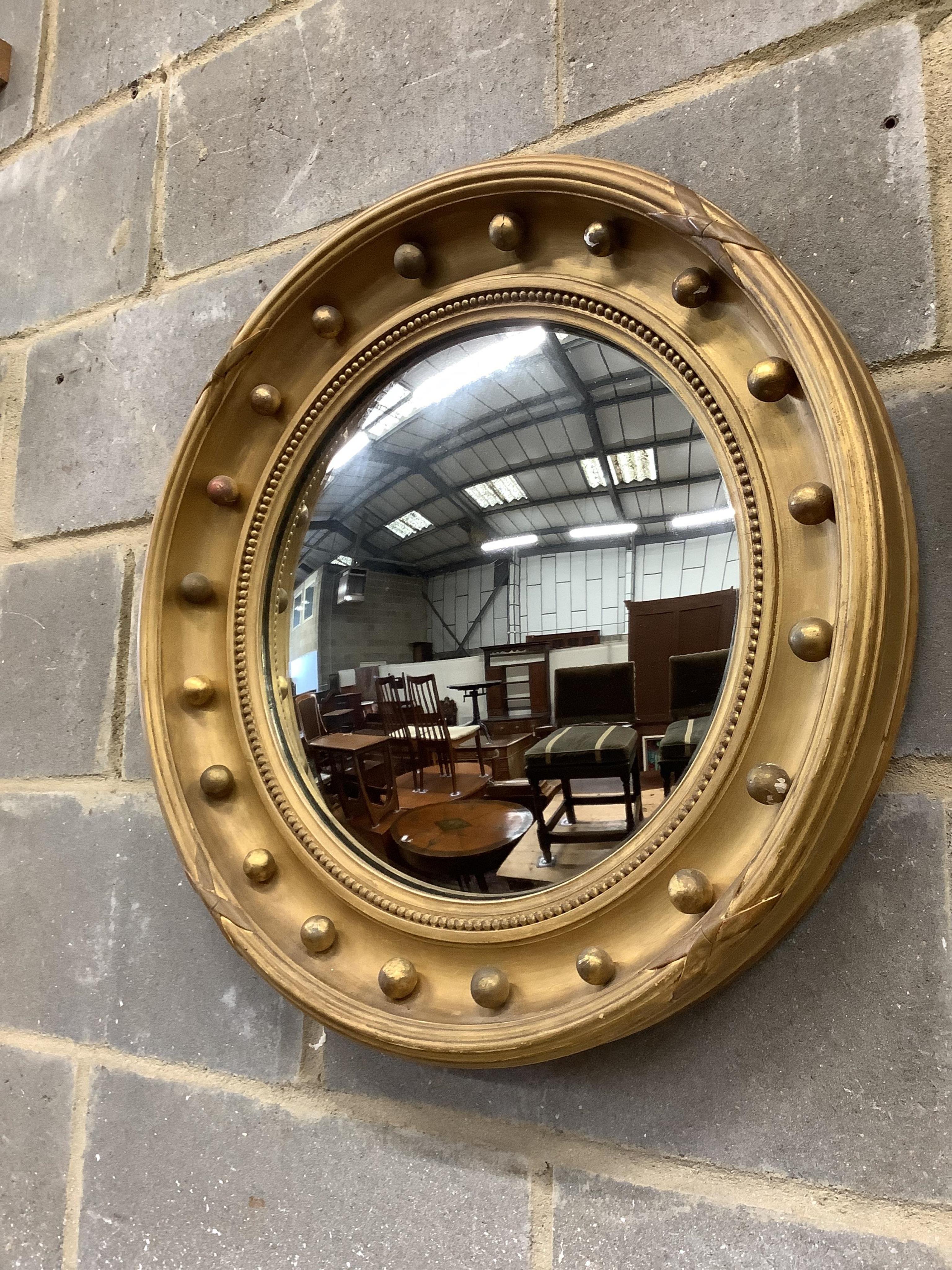 Two Regency style circular giltwood and composition convex wall mirrors, larger diameter 58cm. Condition - fair